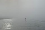 Foggy morning on a beach, figure in the distance