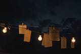 papers and candles at night hanging from a cord or rope