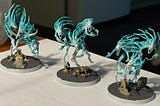 Three ghost-themed Warhammer Nighthaunt miniatures sit on a table.