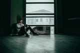 A man on a mobile phone in a dark room. Don’t let doomscrolling derail you.