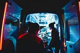 The inside of an ambulance with three paramedics and medical equipment.