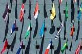 Image of assorted colored flags on a wall during day time