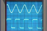 Closeup of sine wave and square wave on Tektronix oscilloscope