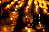 An altar of candles. An Angel is printed on the small glass candle holders.