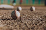 Scuffed baseballs on a dirt infield