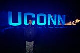 01: บรรยากาศของป้ายไฟ UCONN ที่ส่องสว่างในช่วงดึกสงัดของคืนหนึ่ง