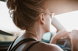 Woman in sunglasses driving in a hot car