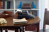 A writing desk with a typewriter on it