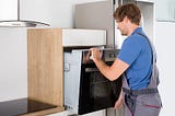 Handyman in Mississauga installing kitchen appliance
