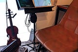 Empty chair in a practice room with violin and accordion