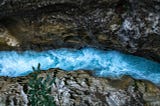 Overhead view of turbulent water running through a channel in bedrock.