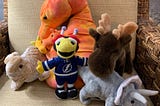 A lop-eared, tan bunny; an orange seahorse with three babies in its pouch, Thunderbug in his Lighting jersey, a moose, and a grey-and-blue triceratops.