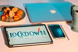 A tablet, apple mac laptop, and and iphone on a table showing work from home during lockdown. Photo by Elena Mozhvilo