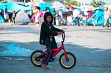 a young immigrant boy on a bike