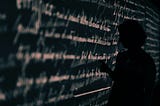A person standing in front of a board filled with blurred sentences from top to bottom.