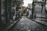 Cobblestone street through a cemetery