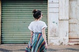 Girl in colourful skirt crossing road after quitting job