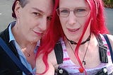 outdoor photo of Abbie (hoop earrings) and Fae (long red hair and glasses)