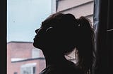 Silhouette Photo of a Woman Looking Through Window