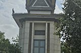 Choeung Ek Genocidal Center memorial. white concrete with a pagoda style roof.