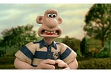 The character “Wallace” articulating the word “that’s” — the tip of his tongue is visible between his teeth.