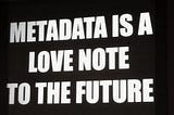 Black sign with white text in block letters reading: “Metadata is a love note to the future”