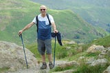 An older man out hiking in the mountains