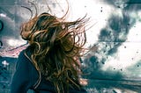 a woman with long and wildly wind-whipped auburn hair
