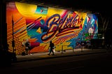 Colorful, urban mural on the street with word, “Believe”.