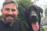 PC Jonathan Myles (smiling) and PD Henry (with his tongue out), side by side posing for the camera