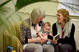 A new mother is shown baby signal cue cards by a social worker from Bradford District Care NHS Foundation Trust.