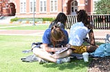 Female student on Samford Lawn writing in her notebook.