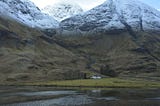 Scotland’s mountains and valleys, with a small cottage in the wilderness