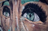 A graffiti on a wall: the upper part of a human face, eyes and eyebrows.