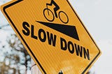 image of sign to slow down on a steep hill