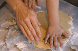 Graphic of 3 hands, Mom, Dad, and child preparing cookie dough
