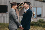 My husband and I standing in our back yard in front of a copper arch, decorated in florals.