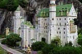 A beautifully detailed castle made out of LEGO bricks set outside in nature so that it resembles a real castle.