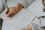 Person writing in a notebook.