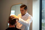 Dr. Balwi examining a patient’s scalp and donor area during a hair transplant assessment.