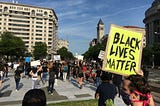 A protestor at a Black Lives Matter rally holds up a sign that reads, “Black Lives Matter.”