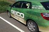 Geico Faces $2M Settlement Over Unpaid Replacement Fees — Geico logo car
