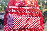 Woman holds stack of packages in red holiday wrapping