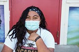 Young girl sitting, smiling at the San Francisco 49ers Academy in East Palo Alto