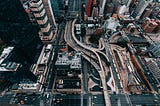 Looking straight down at large city streets and overpasses in an urban center.