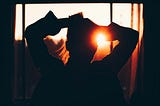 Woman looking at sun through window