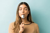 A young woman tasting spoon