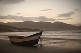 Small boat beached on a lonely shore.