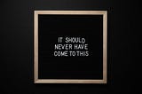 a white text on a black chalkboard with bronze borders, saying “It should never have come down to this.”