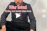 A paused video of a man (Hamada Shoo) sitting in front of a cutting board captioned “War bowl Today our lunch was tuna bowl” in front of a tarplike material